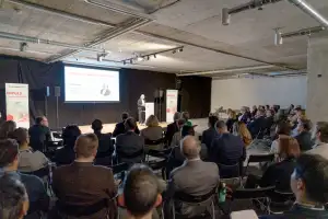 Das Bild zeigt das Publikum von hinten bei einer Podiumsdiskussion 