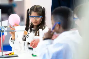 Das Bild zeigt zwei Kinder beim Experimentieren.