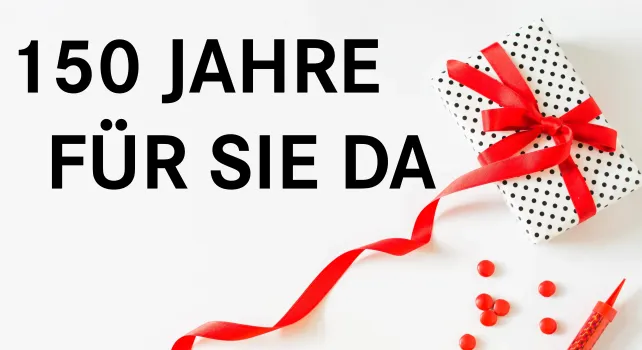 Das Bild zeigt ein Geschenk auf einen Tisch mit Schleife.
